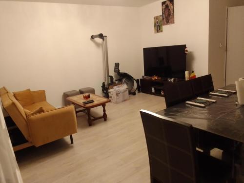 a living room with a couch and a television at Superbe chambre dans maison neuve, propre et bien aérée in La Verrière