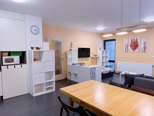 a room with a table and a desk with a clock at Mountain apartment Klinovec Hexagon B14 in Loučná pod Klínovcem