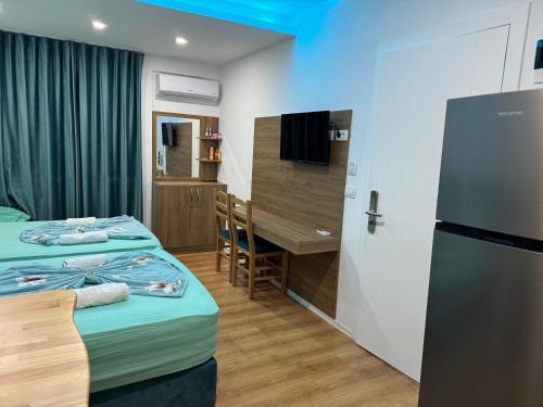 a small room with two beds and a desk at Suite Rana Hedhun in Shëngjin