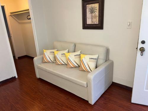 a white couch with pillows on it in a room at The Dylan, a Baymont by Wyndham in Seattle