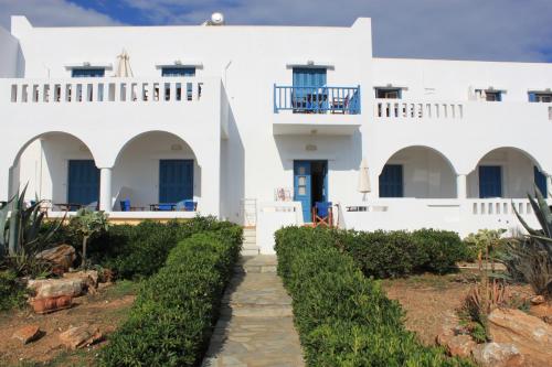 a white house with a pathway in front of it at Kouros Village in Antiparos Town