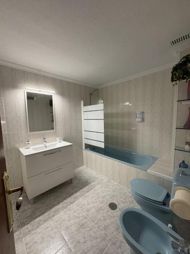 a bathroom with two toilets and a sink and a tub at Apartamentos La Laguna II in Los Alcázares
