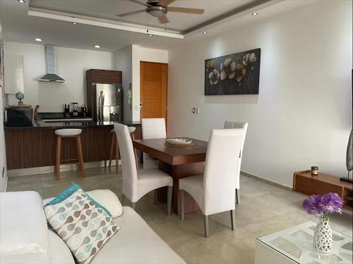 a living room with a table and white chairs at Central Luxury Apartment Playa del Carmen in Playa del Carmen