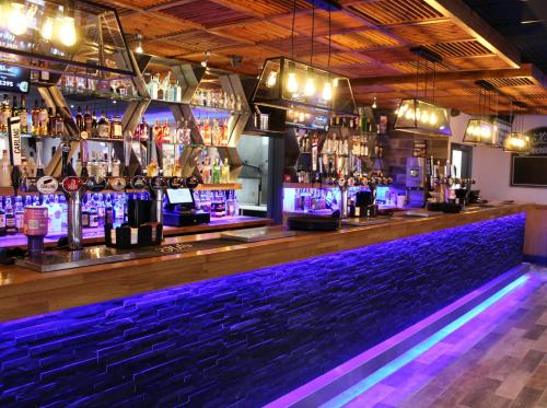 a bar with purple lights on the bar counter at Golden Palm Resort - Sequoia Palm - Coastal Caravan Breaks in Chapel Saint Leonards