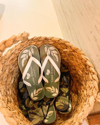 a pair of shoes sitting in a basket at Casa d'Aroeira Residencial Boutique - Centro de Juqueí - 2 quadras do mar - Serviço de Praia - Roupa de Cama 600 fios algodão Egípcio - Toalhas Banho e Praia - Tudo Novo - Estacionamento Interno - Cozinha - Consulte unidades com Ofurô Hidro e Cromoterapia in Juquei