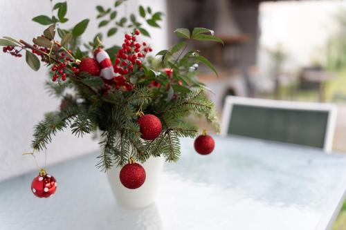 a white vase with christmas decorations on a table at Το σπίτι στο χωριό in Tríkala