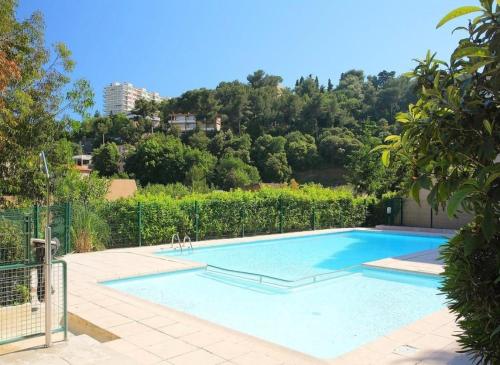 - une grande piscine dans une cour arborée dans l'établissement L Olivier - Vue mer - Clim - Piscine - Tennis - 6p, à Nice