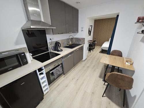une cuisine avec des appareils en acier inoxydable et une table dans l'établissement Appartement Type 1 avec parking, à Saint-Priest
