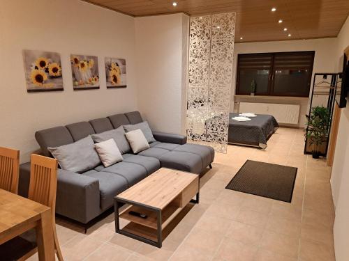 a living room with a couch and a table at Sonnen 1 - Erdgeschoss-Wohnung mit Arbeitszimmer und Parkplatz in Bexbach
