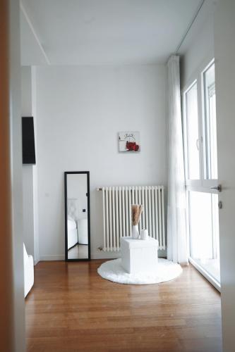 a white living room with a mirror and a table at NSH Apart Malpensa in Gallarate