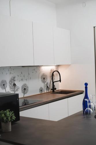 a kitchen with a sink and a counter top at NSH Apart Malpensa in Gallarate