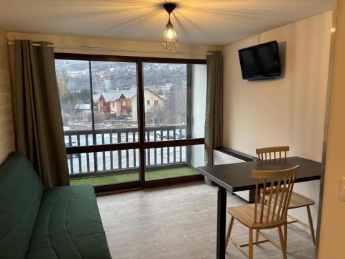 d'un salon avec une table et une vue sur un balcon. dans l'établissement Studio Tezoto, à Briançon