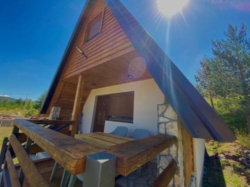 a cabin with a wooden roof and a wooden table at Srce Zminice in Žabljak