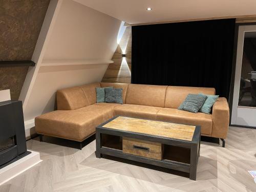 a living room with a couch and a tv at Forest Lodge Durbuy in Durbuy
