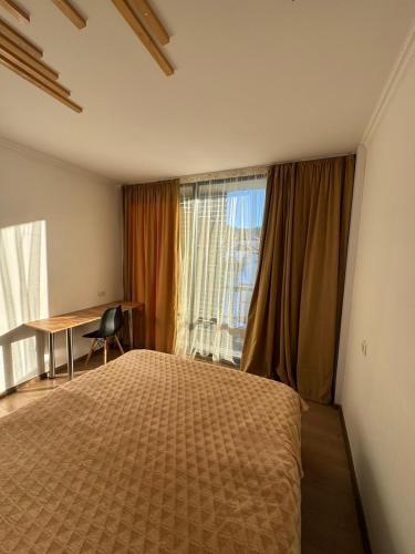 バクリアニにあるBakuriani Mgzavrebi Block 9 Aparment 501のベッドと机と窓のある寝室