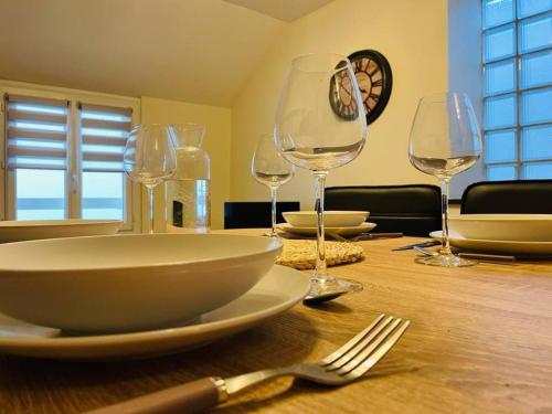 une table avec des assiettes et des verres à vin dessus dans l'établissement Chez Delphine et Sébastien, à Romorantin-Lanthenay