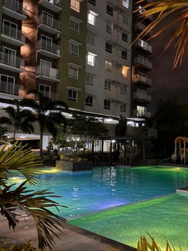 a swimming pool in front of a building at night at Studio McBi in Davao City