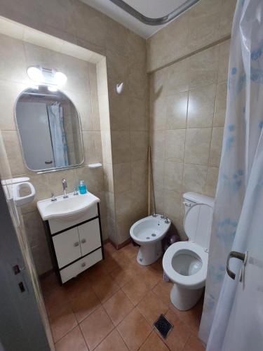 a bathroom with a toilet and a sink and a mirror at Sol y Luna Hospedajes 2 in San Bernardo