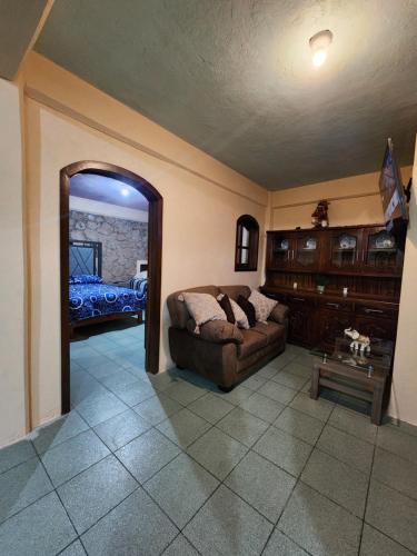 a living room with a couch and a mirror at Casa Gomez in Taxco de Alarcón