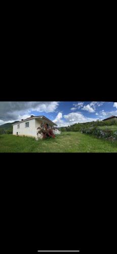 a white house in the middle of a field at Vila Redi in Elbasan