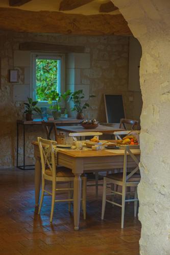 a dining room with a table and chairs in a house at La Cale de la Clauderie in Rigny-Ussé
