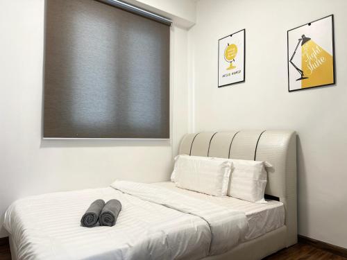 a bedroom with a bed with slippers on it at KK City Homestay K Avenue BMG in Kota Kinabalu