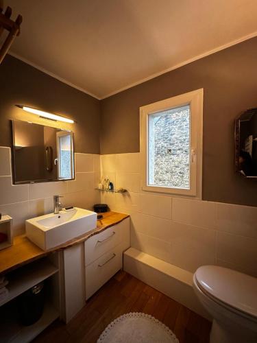 une salle de bain avec un lavabo blanc et une fenêtre dans l'établissement Casa Borgognona, à Vitteaux