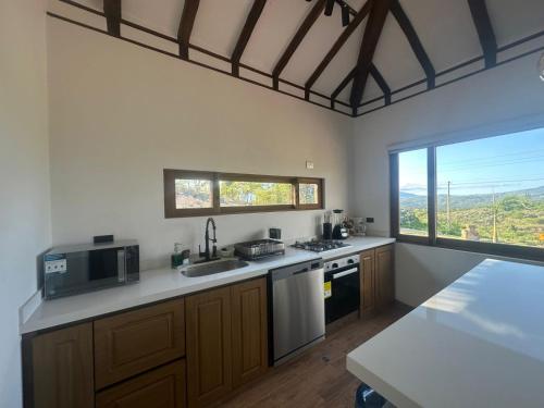 a kitchen with a sink and a microwave at Hotel Sol de la Montaña Villa de leyva in Villa de Leyva