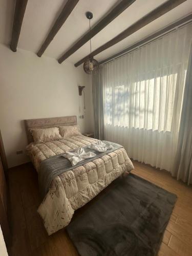a bedroom with a bed and a large window at Hotel Sol de la Montaña Villa de leyva in Villa de Leyva