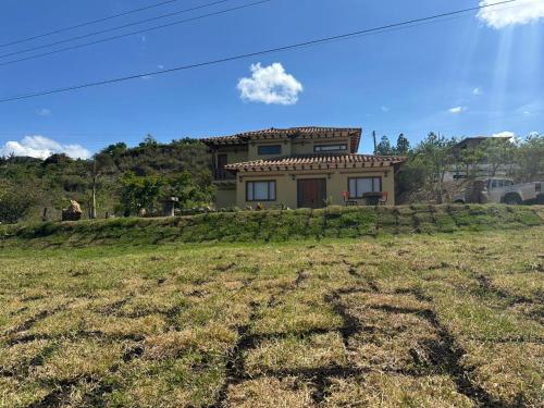 a house on top of a hill with a yard at Hotel Sol de la Montaña Villa de leyva in Villa de Leyva