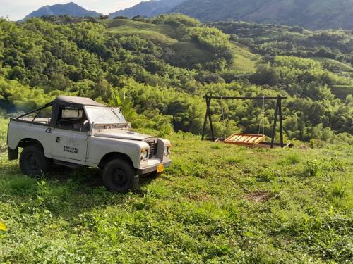 a white jeep parked in a field of grass at Casa Alto Bonito in Quimbaya