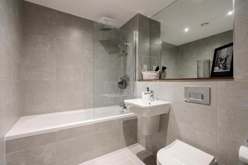 a bathroom with a sink and a tub and a toilet at Jungle Luxe Retreat, 2Bed 2Bath Leeds, Center & Stadium in Leeds