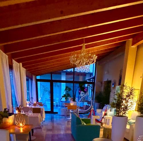 a restaurant with a chandelier and tables and chairs at La Siègià Resort spa in Massa Marittima