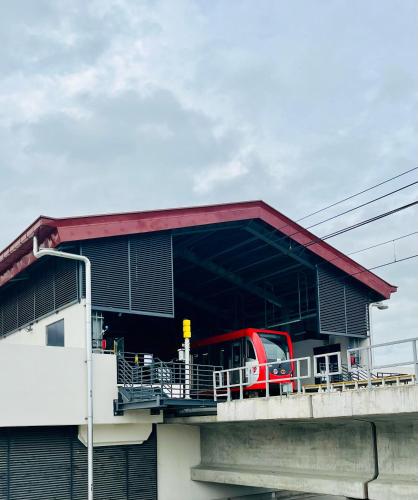 a red train is parked at a train station at QBee Manila, Near Airport, Cozy Spot 301 Third Floor, Local Vibes & Flex Stay in Manila