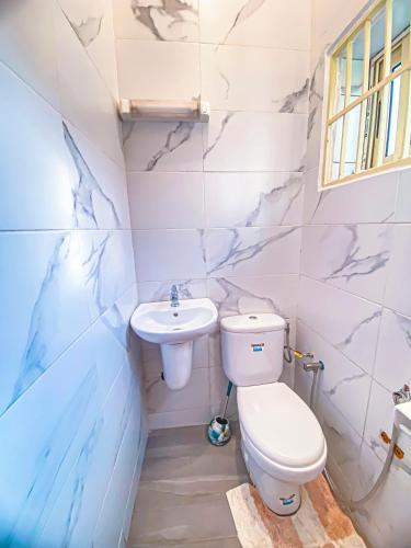 a bathroom with a toilet and a sink at Résidence Raffinée-Pour une expérience unique in Cotonou