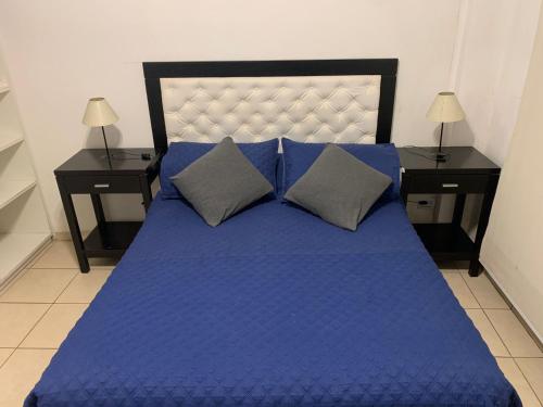1 cama azul grande con 2 mesitas de noche y sidx sidx sidx sidx sidx en Beautiful apartment in the heart of Buenos Aires, en Buenos Aires