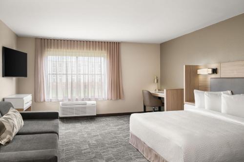 a hotel room with a bed and a desk at SpringHill Suites by Marriott Chicago Bolingbrook in Bolingbrook