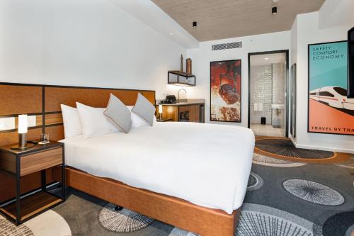 a bedroom with a large white bed and a television at Hoteloco in Sydney