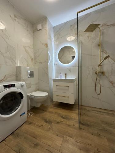 a bathroom with a washing machine and a toilet at Apartament Kosciuszki 33f in Iława