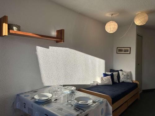Cette chambre comprend une table avec des assiettes et des verres. dans l'établissement Studio coquet à Montgenèvre avec parking, idéal pour 3 personnes - FR-1-330D-64, à Montgenèvre