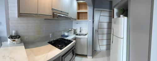 a kitchen with a white refrigerator and a sink at Riverfront Retreat Prime Location Apartment with Stunning Views of the RioNegro in Manaus