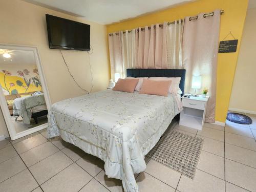 a bedroom with a bed and a tv on the wall at The Sunset Bungalow in Naples