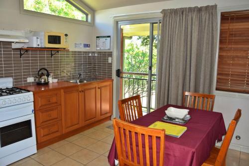 a kitchen with a table with a table cloth on it at Coast and Country Cabin 2 in Pelican Island