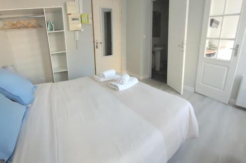 un lit blanc avec deux serviettes dessus dans l'établissement Parfait F1, Entrée du Havre #3, au Havre
