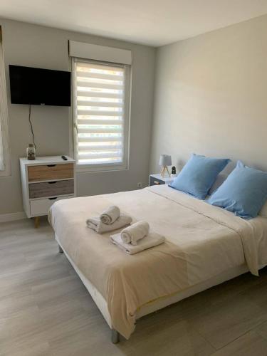 une chambre avec un grand lit avec des serviettes dessus dans l'établissement Parfait F1, Entrée du Havre #3, au Havre