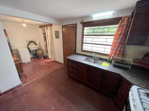 a kitchen with a sink and a window at Casas y Departamentos en Mina Clavero in Mina Clavero