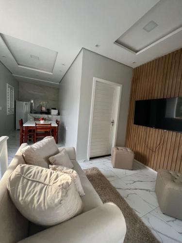 a living room with a couch and a flat screen tv at Apartamento Brisa Icaraizinho Villa brisa Icaraizinho in Amontada