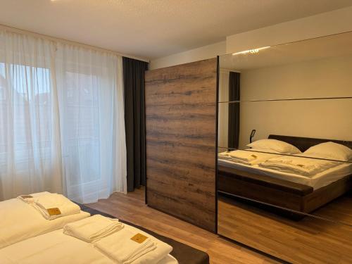 - une chambre avec 2 lits et un grand mur en bois dans l'établissement Between IV, à Lübeck