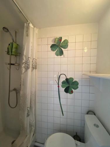 La salle de bains est pourvue de toilettes avec des feuilles vertes sur le mur. dans l'établissement Romantic Studio apt Historical Center Paris Marais, à Paris