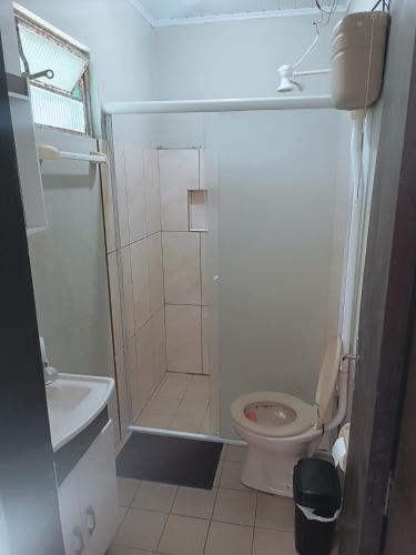a small bathroom with a toilet and a shower at Magistério para veraneio e descanso in Pinhal